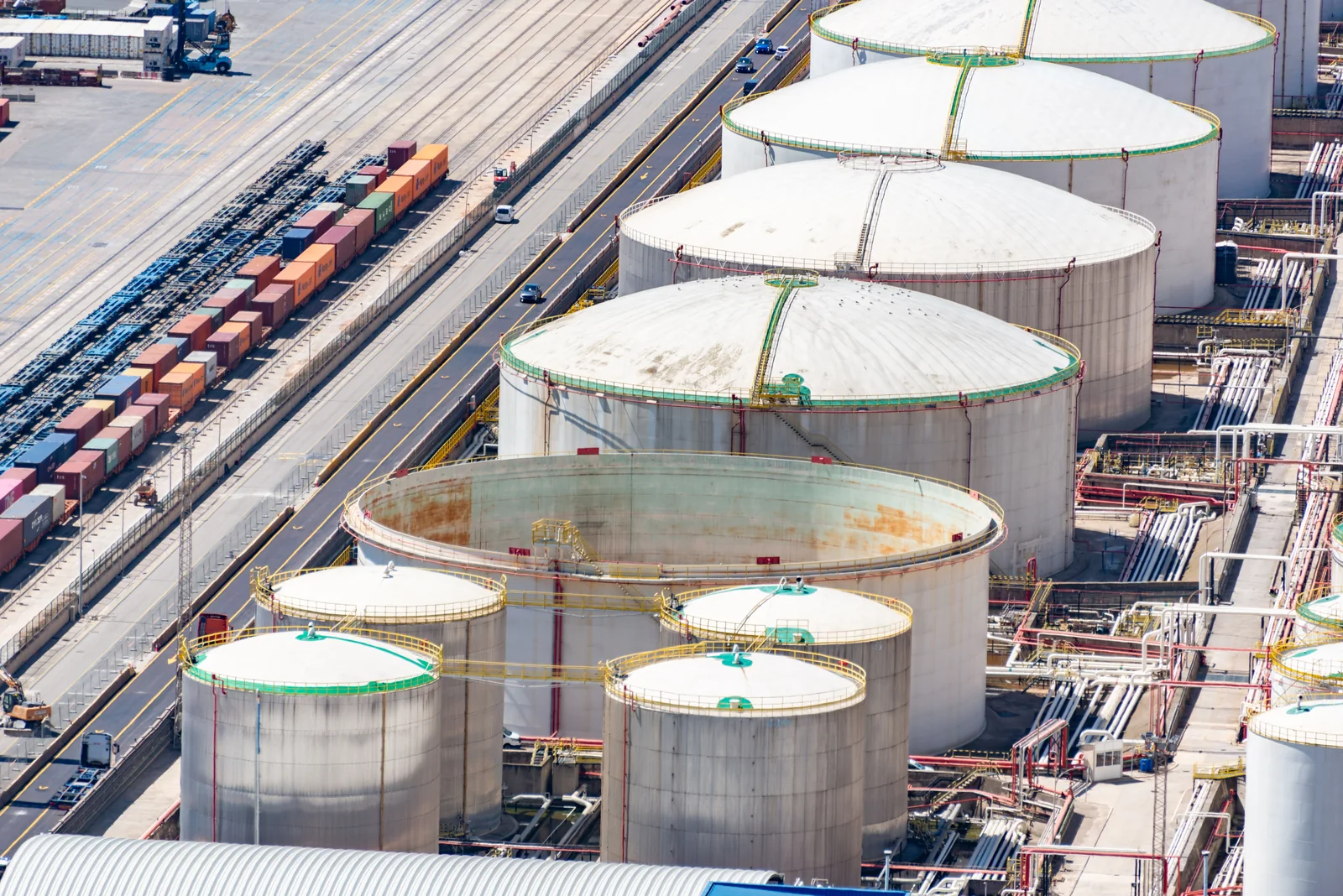 Industrial liquid storage tanks beside rail and container infrastructure