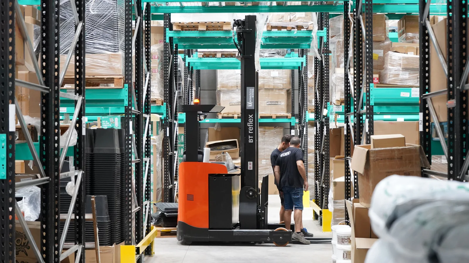 Workers and a forklift operating inside a modern warehouse